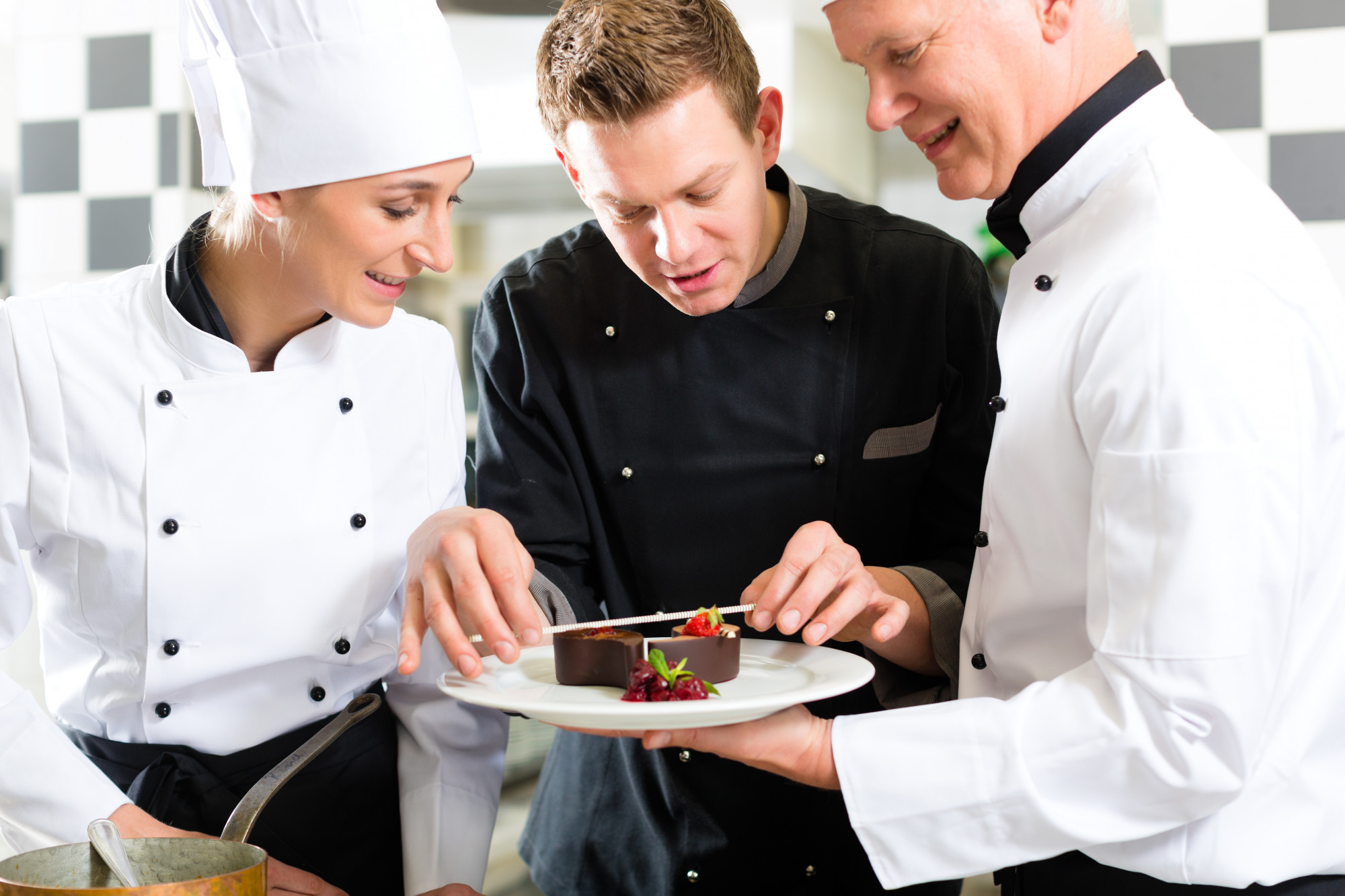 Students plating dishes on white plates